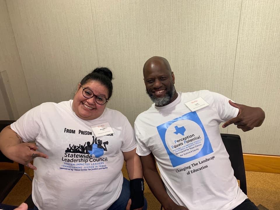 Maggie and Leon smile and point to their shirts in Dallas